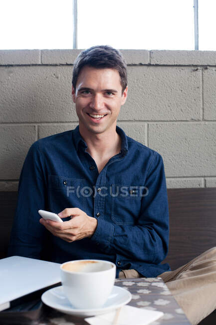 Empresário com smartphone no café, retrato — Fotografia de Stock