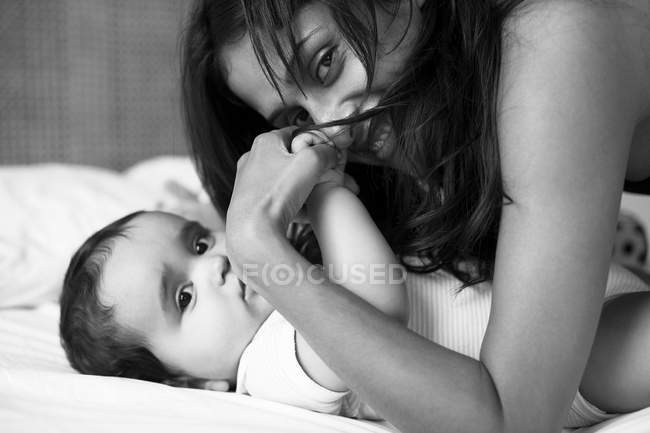 Mother and baby laying on bed — Stock Photo