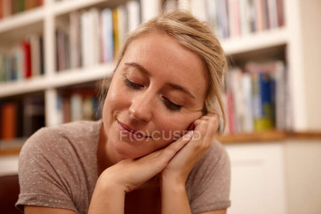 Женщина с закрытыми глазами и рукой на подбородке — стоковое фото
