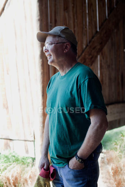 Mature agriculteur regardant loin, souriant — Photo de stock