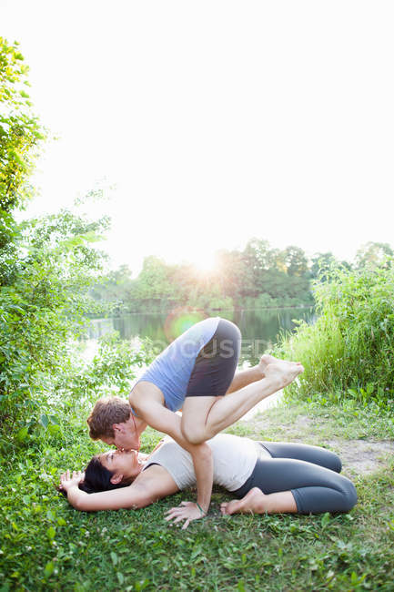 Couple kissing and practicing yoga — Stock Photo