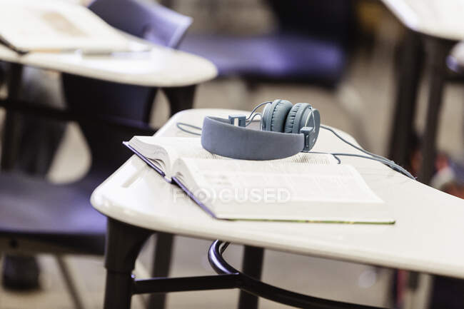 Livro de texto e fones de ouvido na sala de aula do ensino médio — Fotografia de Stock