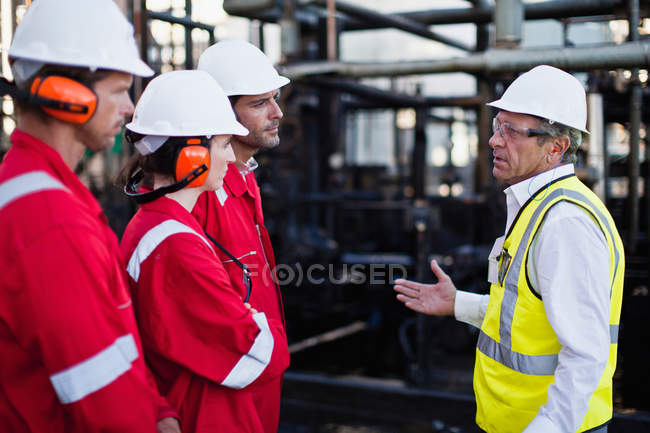 Рабочие разговаривают на химическом заводе — стоковое фото