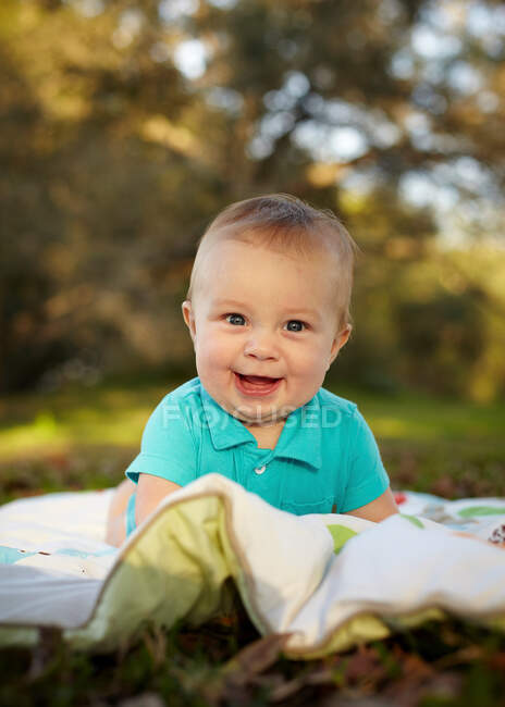 Bébé garçon sur couverture dans le parc — Photo de stock