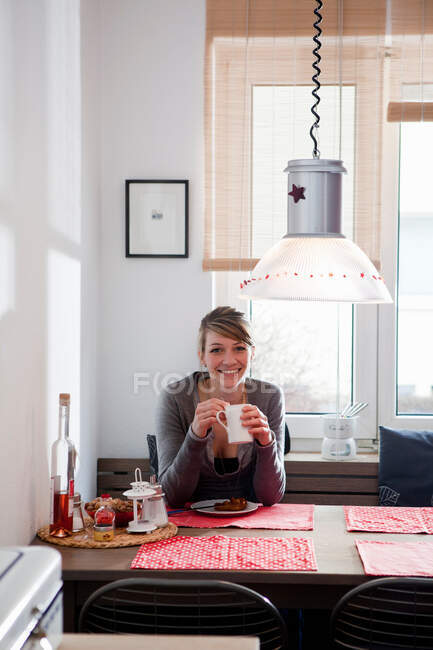 Женщина сидит на кухне — стоковое фото