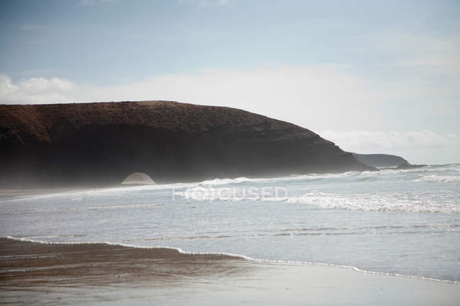 Волны, разбивающиеся на песчаном пляже — стоковое фото
