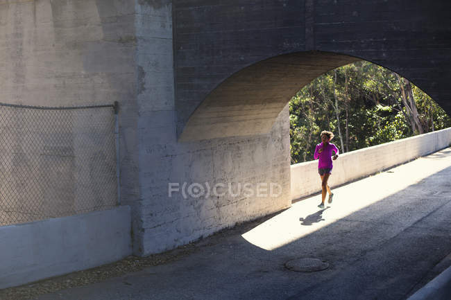 Jogger running on bridge, Arroyo Seco Park, Pasadena, California, Estados Unidos - foto de stock