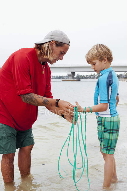 Maestro mostrando a niño cómo utilizar la red de reparto, Sanibel Island, Pine Island Sound, Florida, EE.UU. - foto de stock
