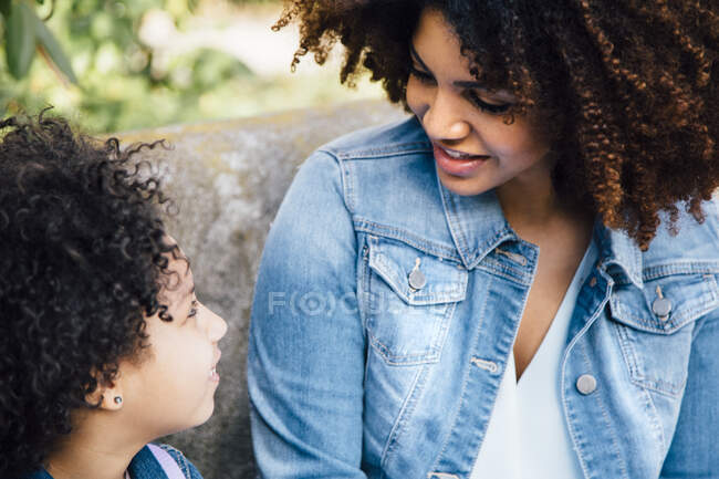Vista ritagliata di madre e figlia seduta faccia a faccia — Foto stock