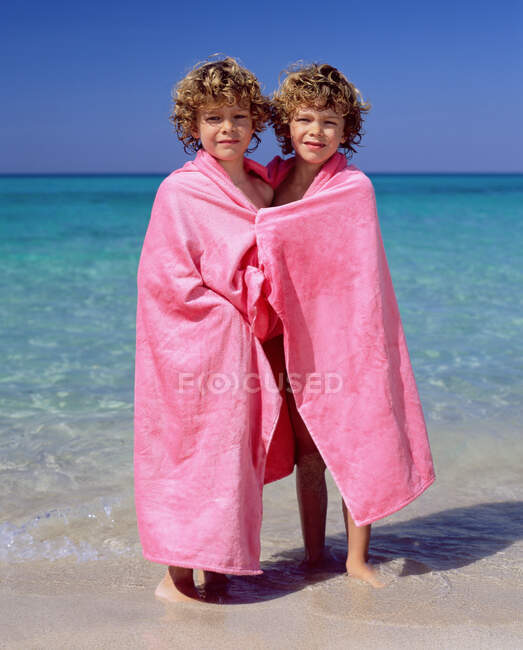 Gemelos envueltos en toallas rosadas - foto de stock
