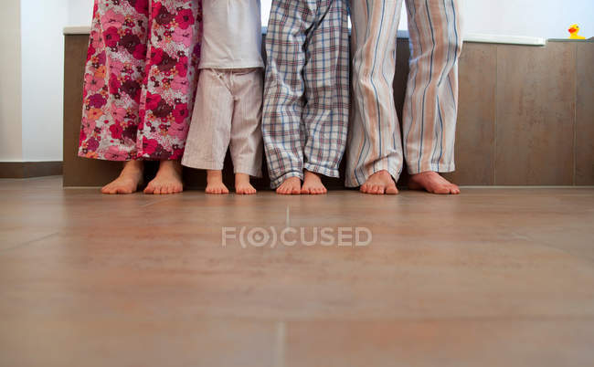 Семья, стоящая в ванной комнате в спальных мешках — стоковое фото