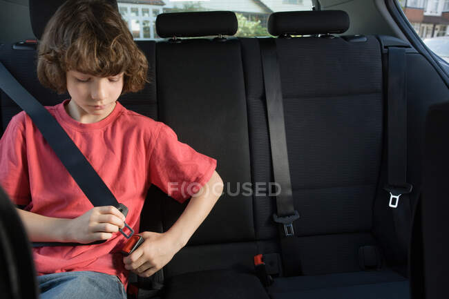 Garçon attachant sa ceinture de sécurité — Photo de stock