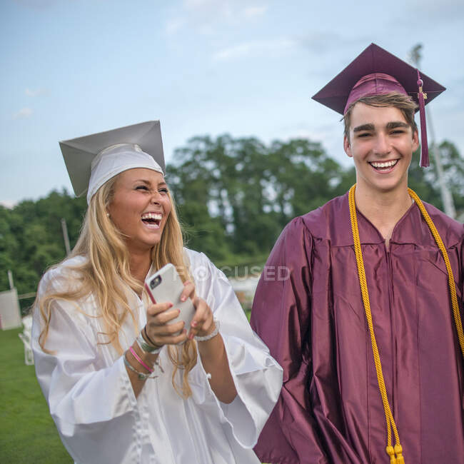Young male and female graduates at graduation ceremony — Stock Photo