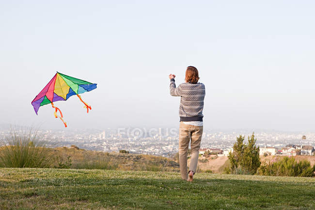 Jovem homem voando um papagaio — Fotografia de Stock