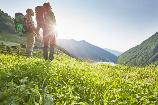Jovem casal caminhando olhando para fora sobre Vernagt reservatório e fazenda Finailhof, Val Senales, Tirol do Sul, Itália — Fotografia de Stock