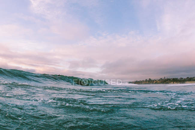 Surfista sull'onda dell'oceano vicino alla costa — Foto stock
