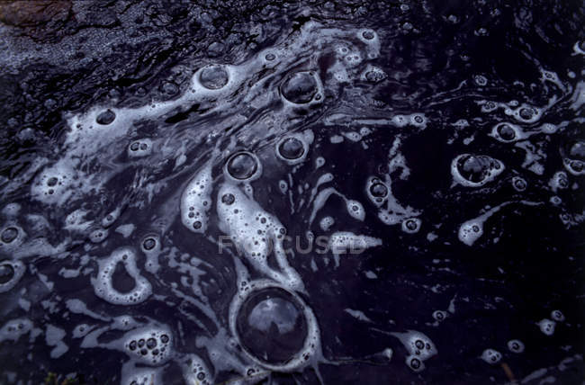 Vista de espuma y burbujas en agua fangosa - foto de stock