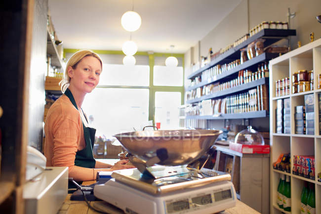 Grocer working behind counter at store — Stock Photo
