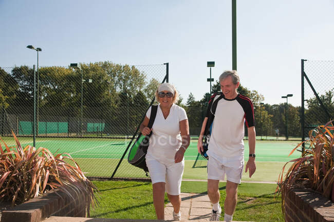 Casal caminhando para campos de ténis — Fotografia de Stock