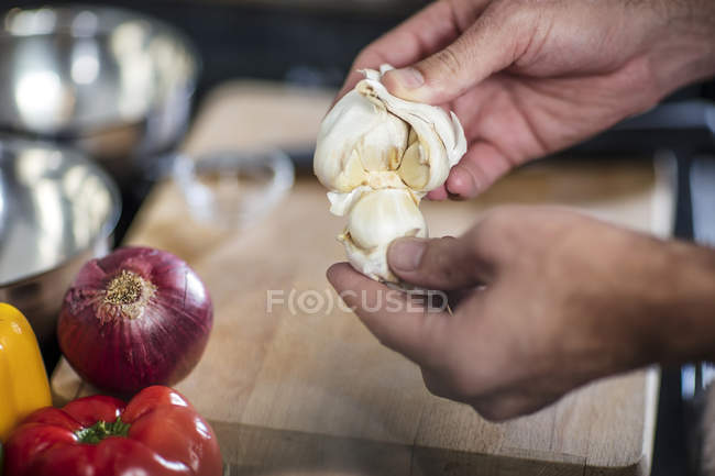 Chef peeling fresh garlic, close-up — Stock Photo
