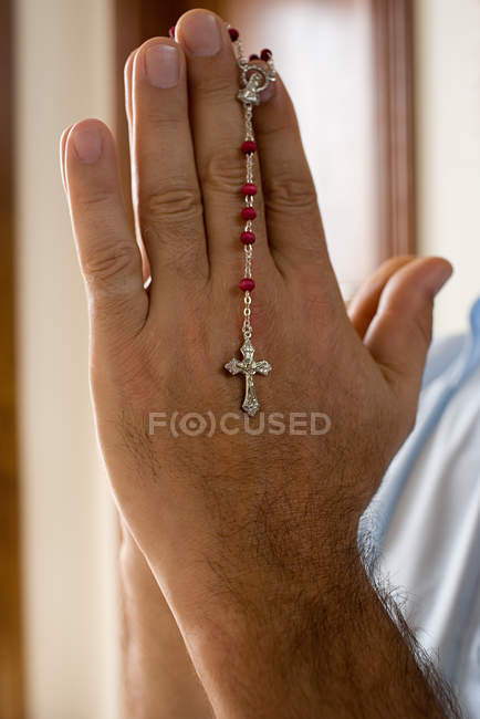 Uomo in possesso di un rosario — Foto stock