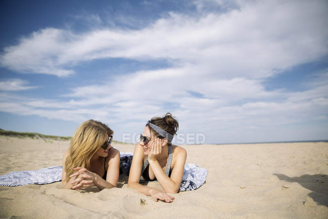 Women relaxing and laying on beach, Amagansett, New York, USA — Stock Photo