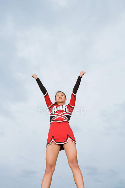 Cheerleader mit erhobenen Armen — Stockfoto