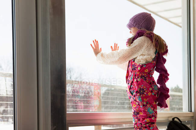 Menina olhando através da janela — Fotografia de Stock