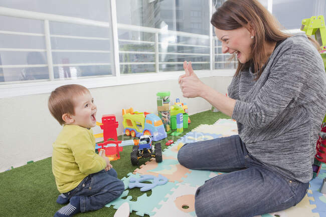 Mãe brincando com filho em casa — Fotografia de Stock