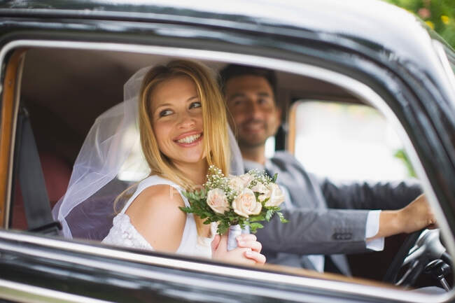Casal de noivas no carro — Fotografia de Stock
