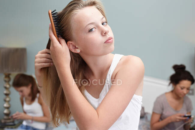 Adolescente brossant ses cheveux — Photo de stock