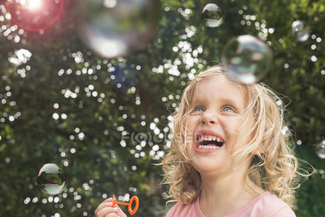 Молода дівчина дме бульбашки, на відкритому повітрі — стокове фото