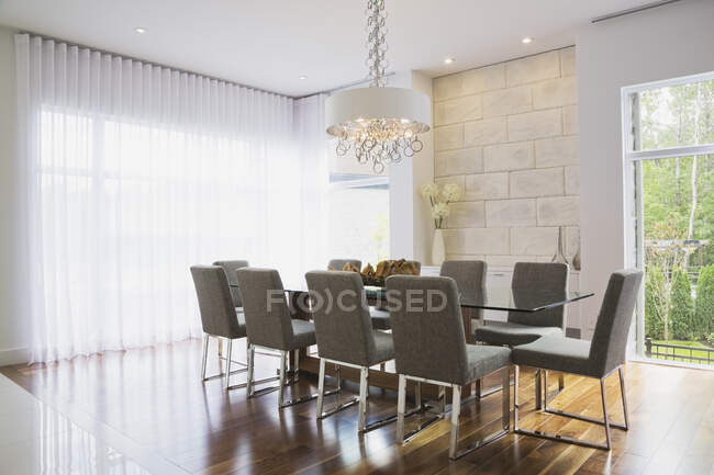 Design de interiores moderno sala de jantar de luxo com mesa de jantar de vidro e cadeiras de jantar estofadas cinza — Fotografia de Stock