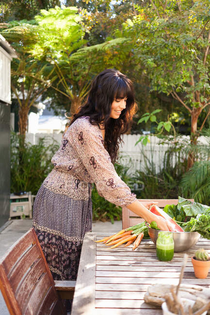 Junge Frau mit Gemüse auf dem Tisch — Stockfoto