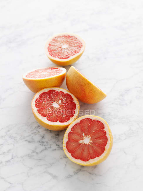 Крупним планом знімок половинок грейпфрута на мармуровій поверхні — стокове фото