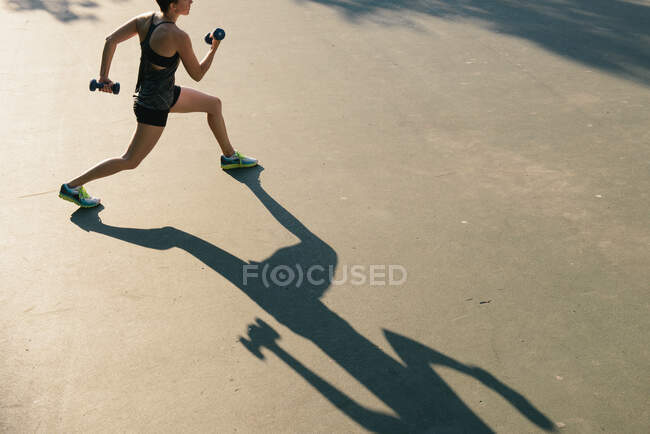 Mulher adulta média, exercitando-se com pesos, ao ar livre, vista elevada — Fotografia de Stock