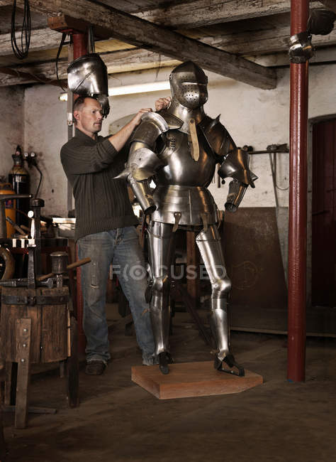 Blacksmith crafting armor in shop — Stock Photo