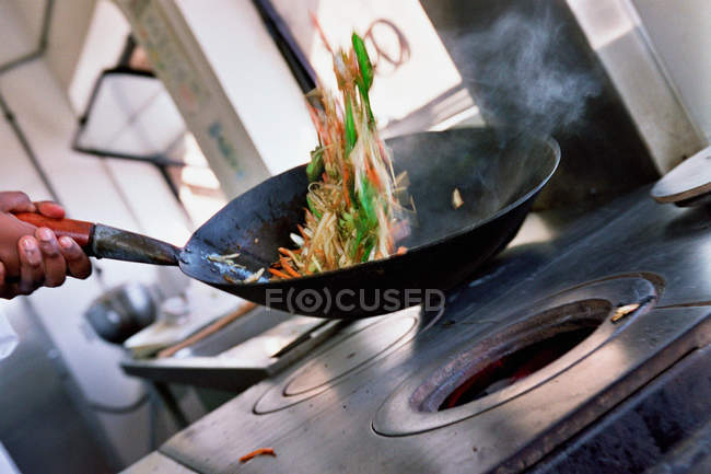 Обрізане зображення шеф-кухаря смажать овочі в проку — стокове фото