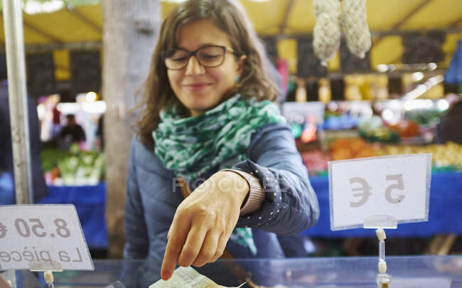 Молодая женщина покупает товары в ларьке — стоковое фото