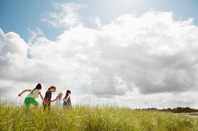 Les filles marchent à travers l'herbe longue — Photo de stock