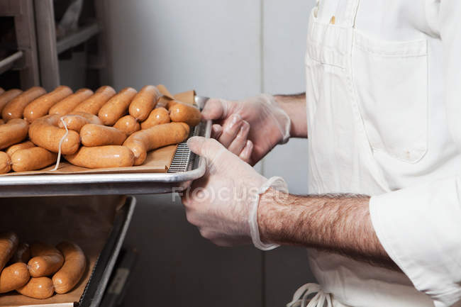 Butcher with tray of sausages — Stock Photo