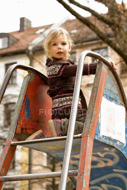 Girl playing on slide outdoors — Stock Photo