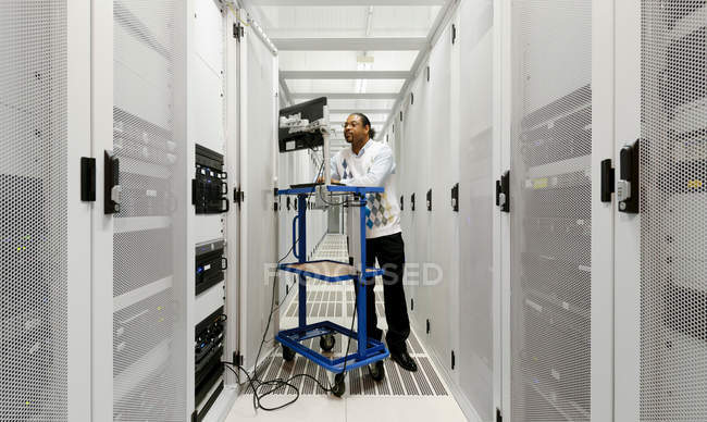 Бизнесмен, использующий компьютер с серверами — стоковое фото