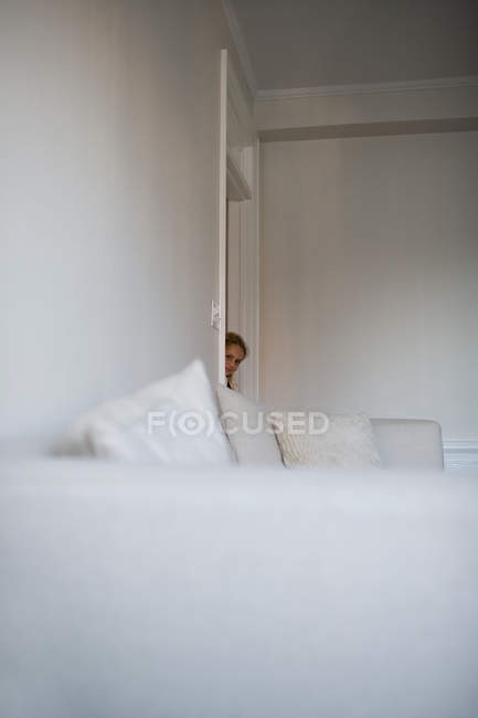 Девушка заглядывает в дверь — стоковое фото