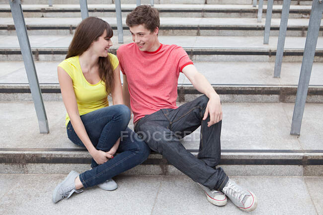 Giovane coppia seduta su gradini — Foto stock