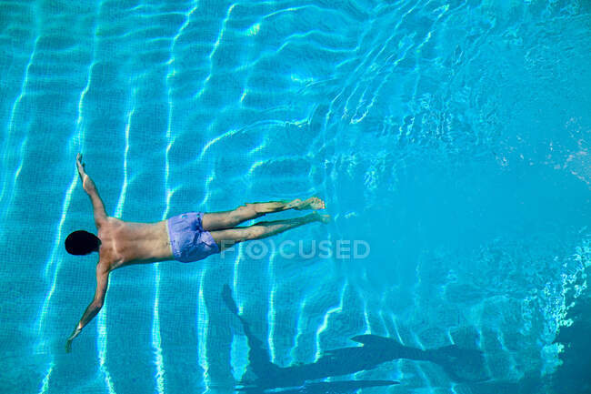 Hombre joven sumergiéndose en la piscina - foto de stock