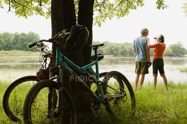 Bicicletas y pareja con prismáticos - foto de stock