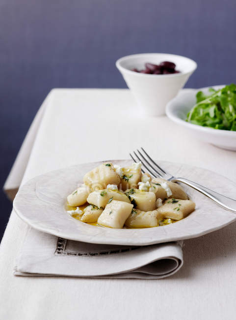 Gnocchi with olives and salads in bowls — Stock Photo