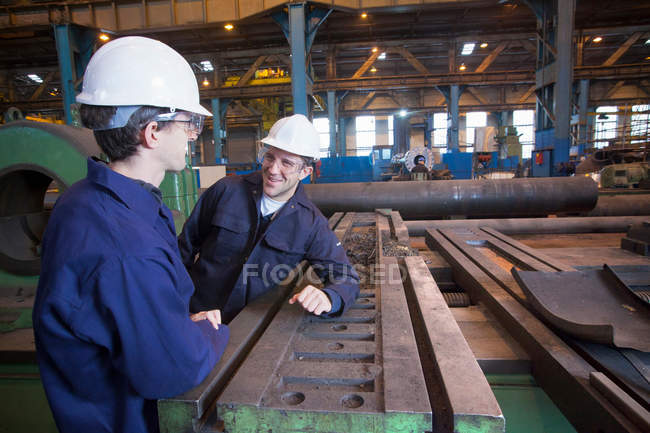 Рабочие разговаривают в стальной кузнице — стоковое фото