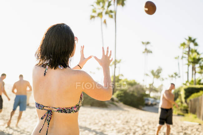 Amigos adultos jogando futebol americano em Newport Beach, Califórnia, EUA — Fotografia de Stock